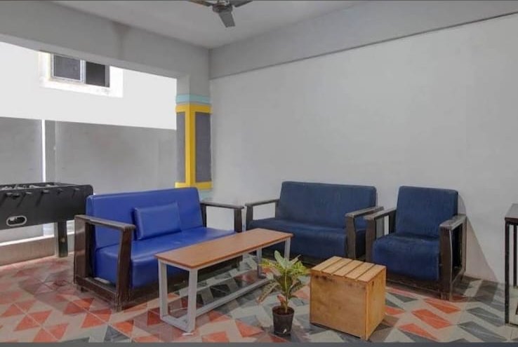 Common lounge area with sofas and foosball table at Orange Stays Hostel